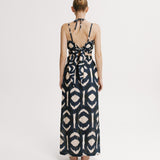 Woman wearing a patterned dress on a white background.