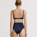 Woman wearing a navy blue bikini set on a white background.