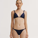 Woman wearing a navy blue bikini on a white background.