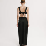 Woman wearing a black dress with open back on a white background