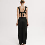 Woman wearing a black dress with open back on a white background