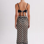 Woman wearing a black and white patterned dress with a white background