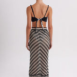 Woman wearing a black and white patterned dress with a white background