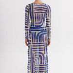 Woman wearing a long, patterned dress on a white background