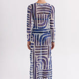 Woman wearing a long, patterned dress on a white background