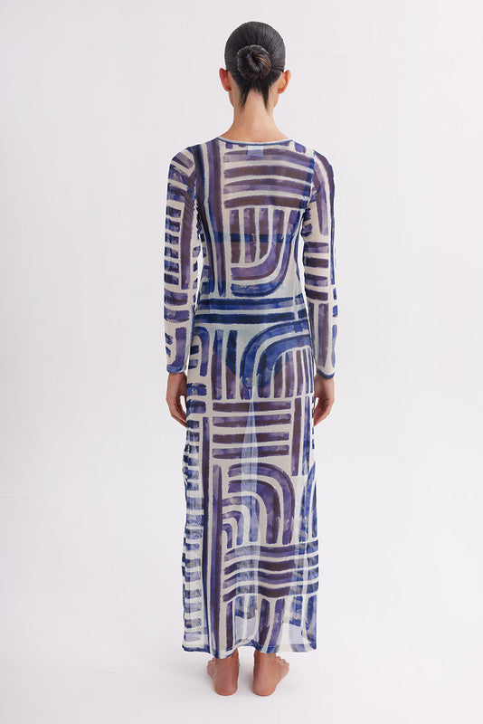 Woman wearing a long, patterned dress on a white background