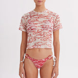 Woman wearing a red and white patterned bikini and crop top on a white background