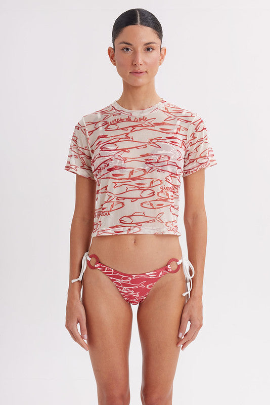 Woman wearing a red and white patterned bikini and crop top on a white background