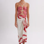 Woman wearing a red and white patterned top and skirt on a white background