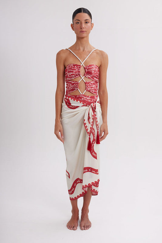 Woman wearing a red and white patterned top and skirt on a white background