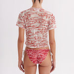 Person wearing a red and white patterned outfit on a plain background