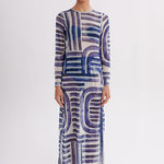 Woman wearing a long, patterned dress on a white background