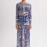 Woman wearing a long, patterned dress on a white background