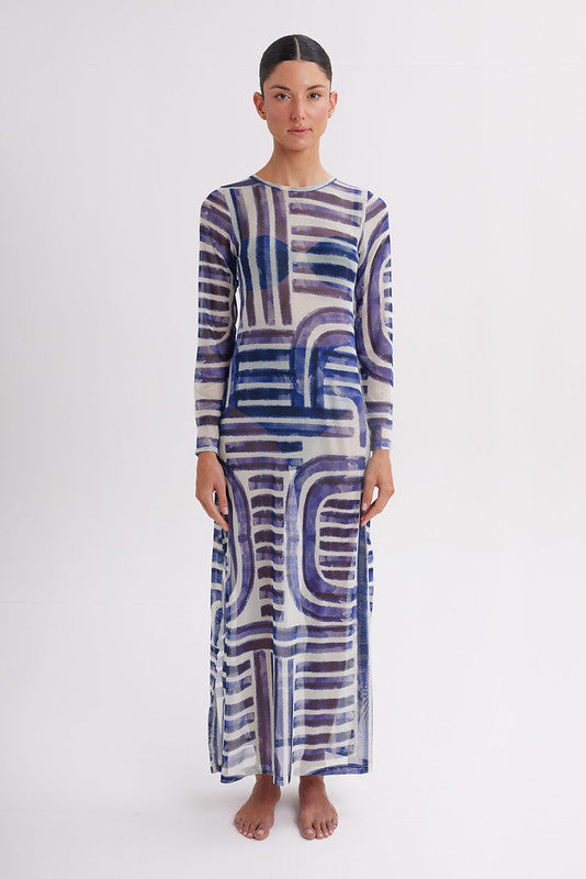 Woman wearing a long, patterned dress on a white background
