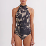 Woman wearing a black and white striped swimsuit on a white background