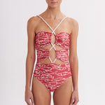 Woman wearing a red and white patterned swimsuit on a white background