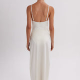 Woman wearing a white slip dress on a plain background. Skirt available at EVAMAIA.