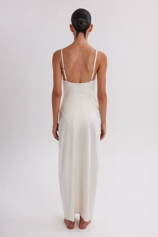 Woman wearing a white slip dress on a plain background. Skirt available at EVAMAIA.