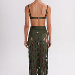 Person wearing a green cut-out skirt on a white background