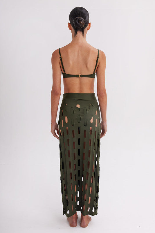 Person wearing a green cut-out skirt on a white background