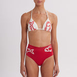 Woman wearing a red and white bikini with a logo on a plain background