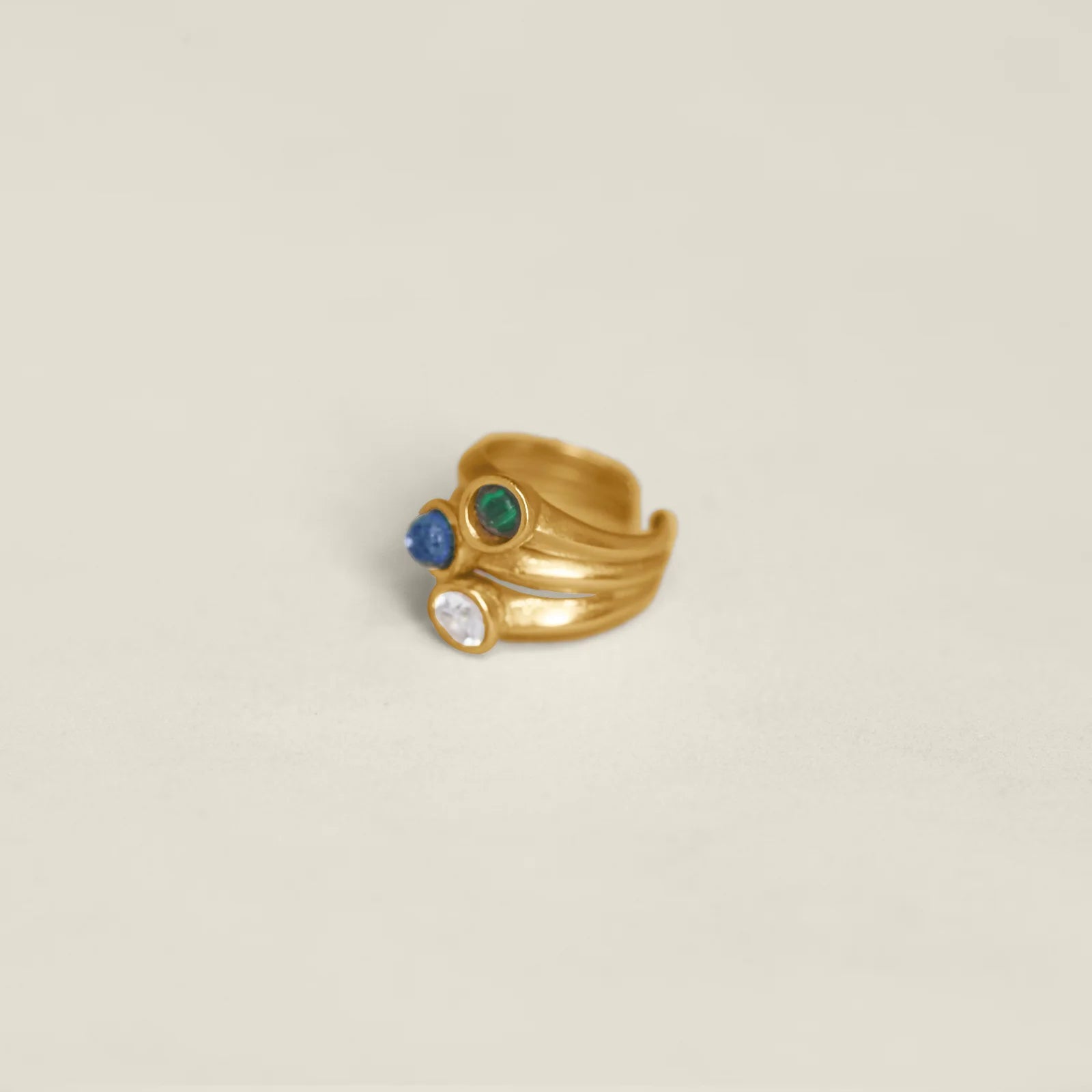 Gold ring with colorful gemstones on a white background.