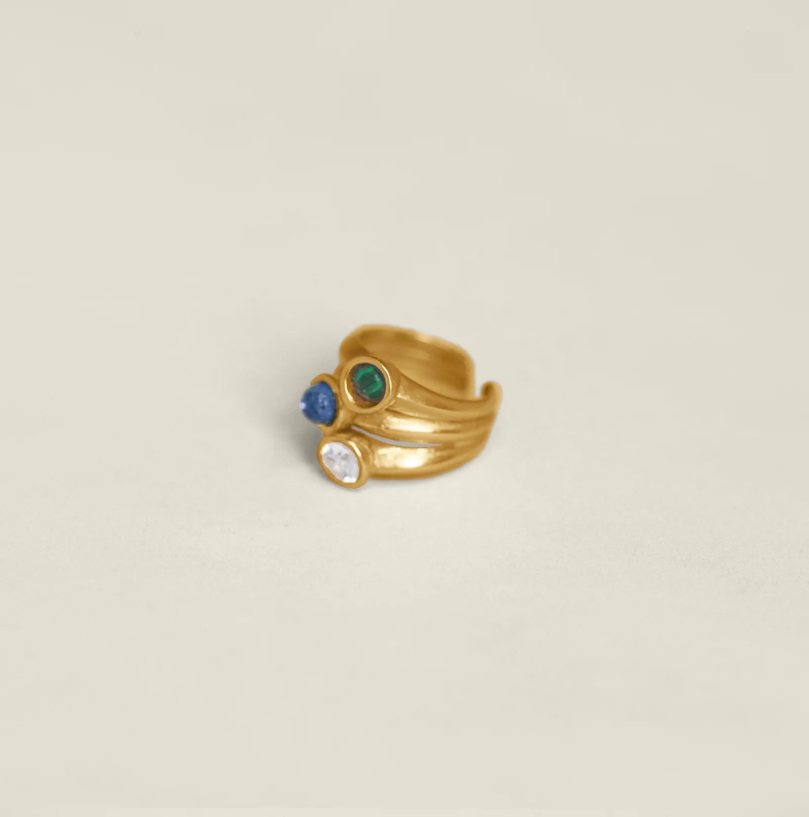 Gold ring with colorful gemstones on a white background.
