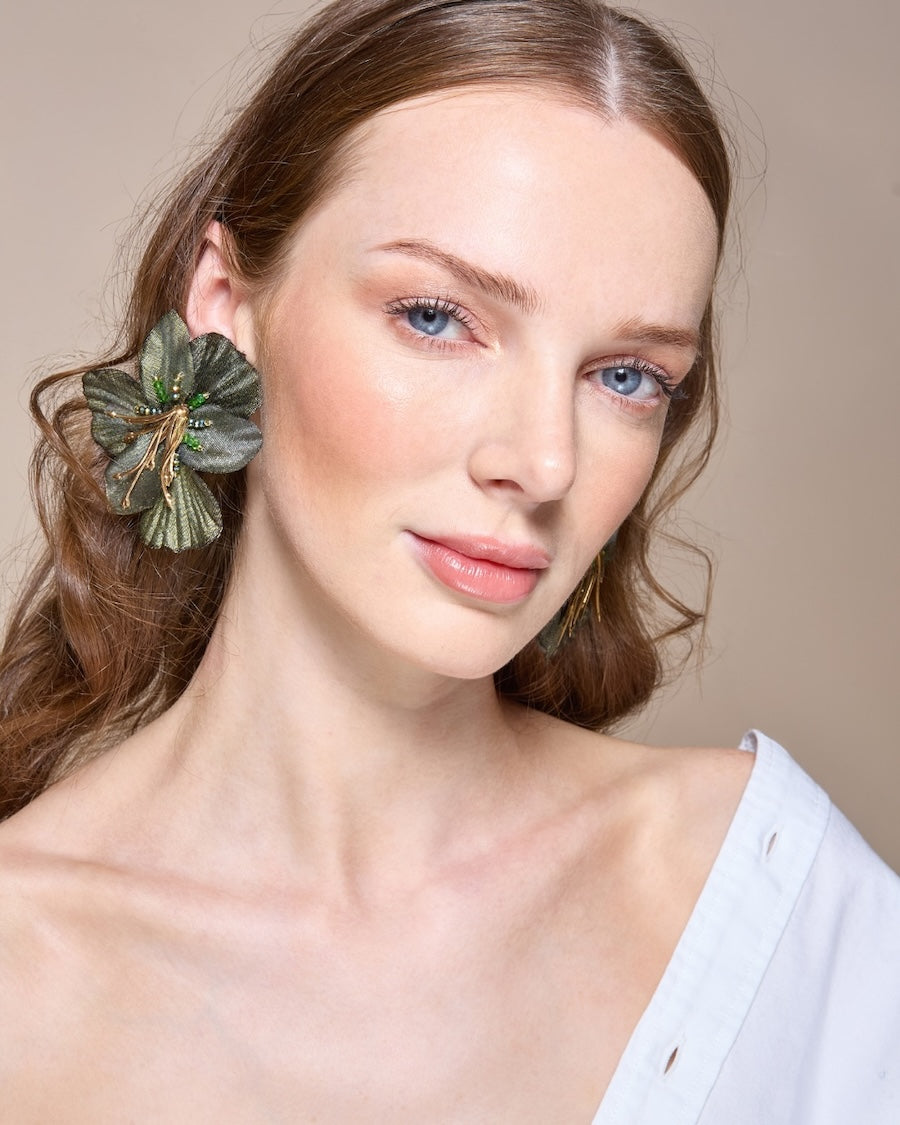 Woman with a floral hair accessory against a neutral background