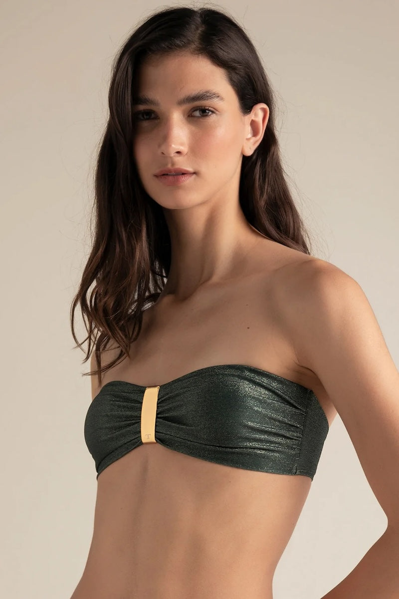 Woman wearing a green strapless bikini top against a neutral background.