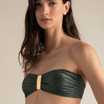 Woman wearing a green strapless bikini top against a neutral background.