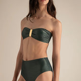 Woman wearing a green bandeau bikini against a beige background.