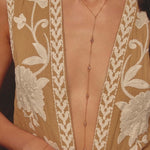 close up of a model wearing a gold lariat necklace - available at EVAMAIA