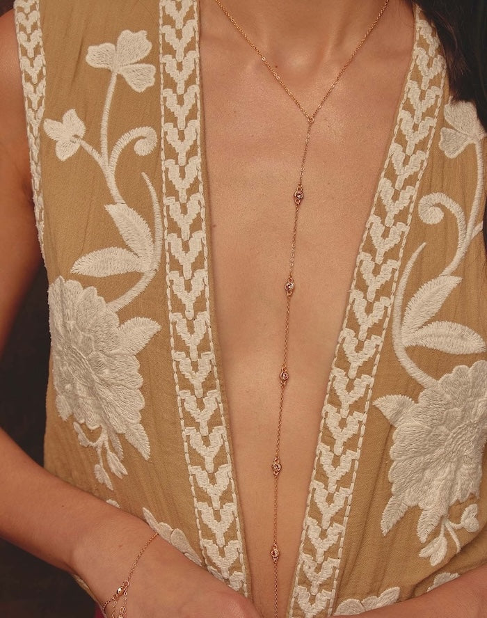 close up of a model wearing a gold lariat necklace - available at EVAMAIA