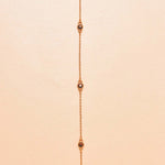 24k gold-plated necklace with small stones on a beige background