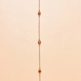 24k gold-plated necklace with small stones on a beige background
