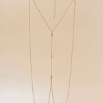 Gold chain necklace on a beige background