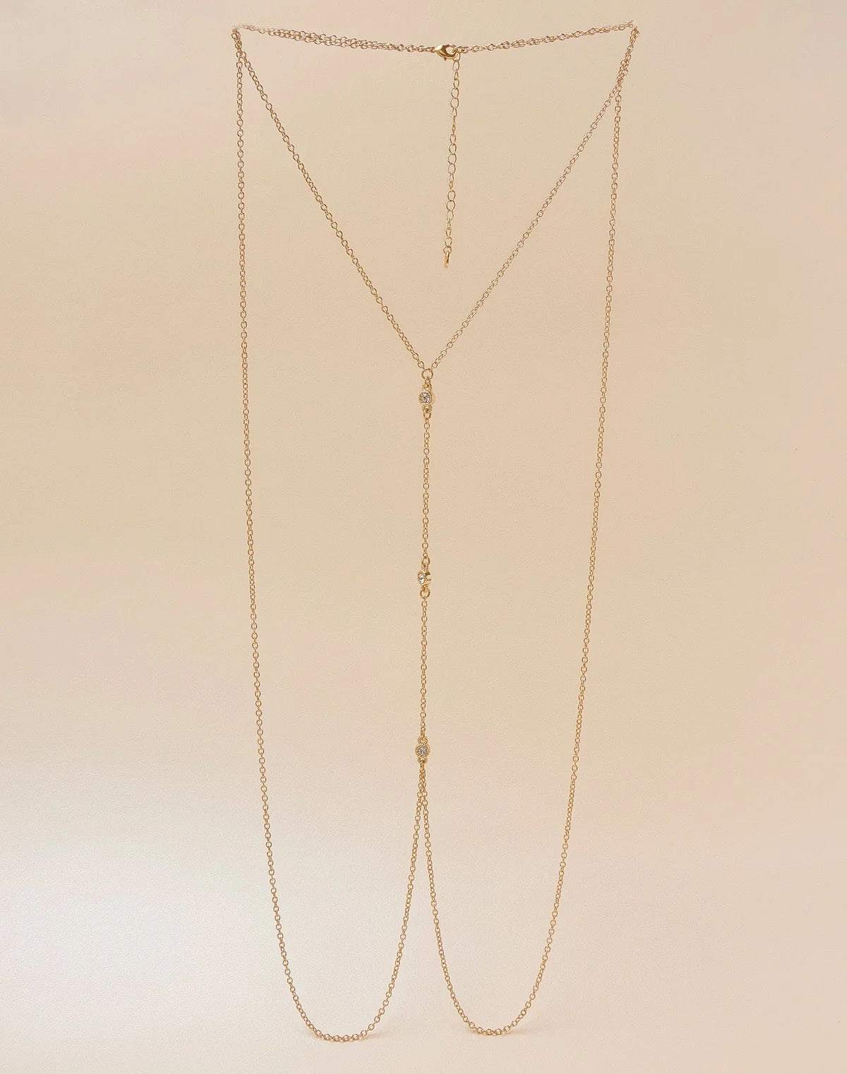 Gold chain necklace on a beige background