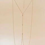 Gold chain necklace on a beige background