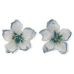 Pair of floral earrings with white and blue petals and gold centers on a white background