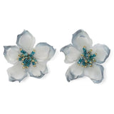 Pair of floral earrings with white and blue petals and gold centers on a white background