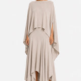 Woman wearing a beige one shoulder blouse over a layered skirt on a white background