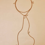 Delicate gold necklace with small pearls on a beige background