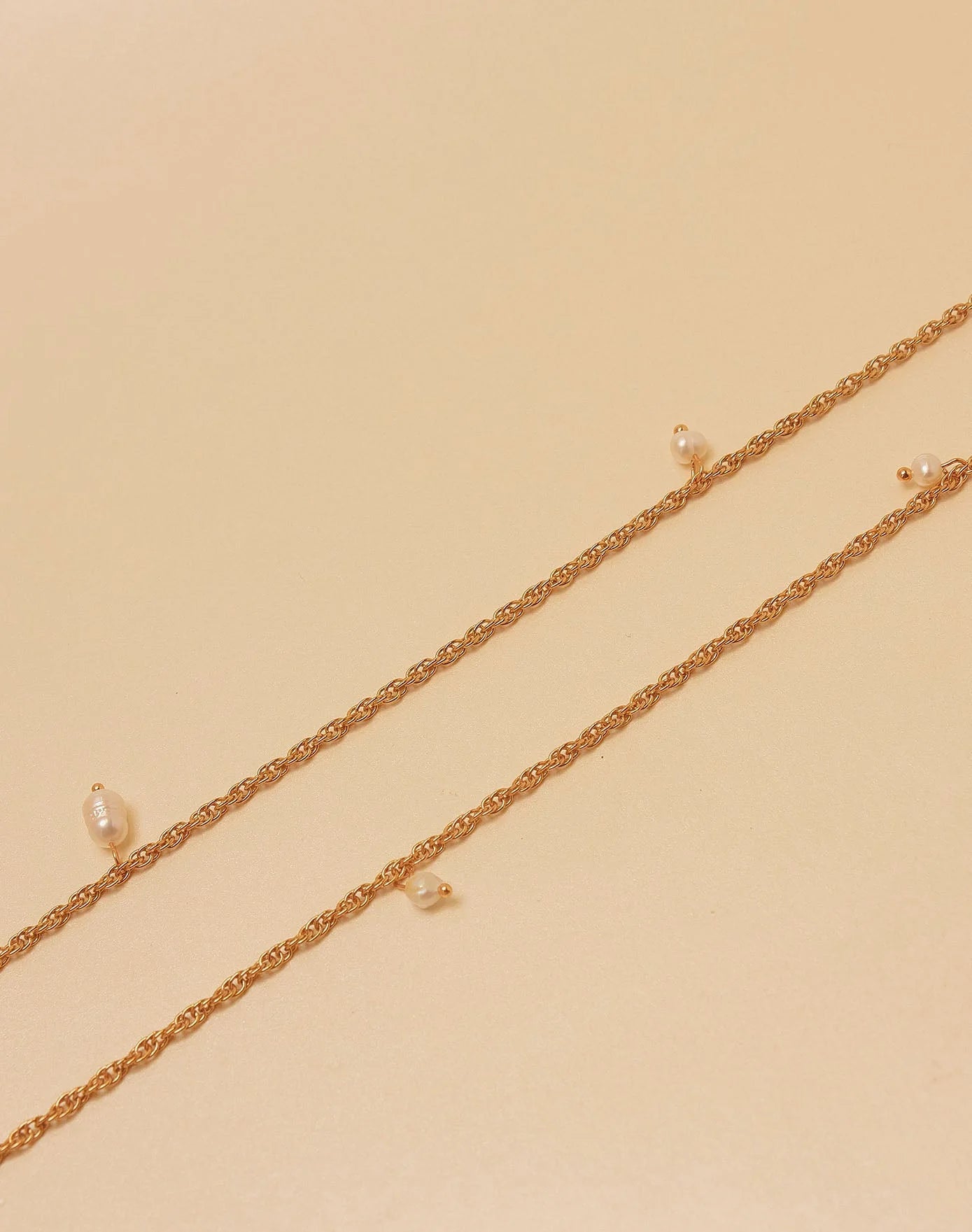 Long natural pearl necklace with 24k gold plating tied at chest, handmade in Colombia