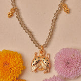 Necklace with a gold pendant on a beige background with flowers