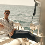 Man sitting on a boat with ocean in the background.