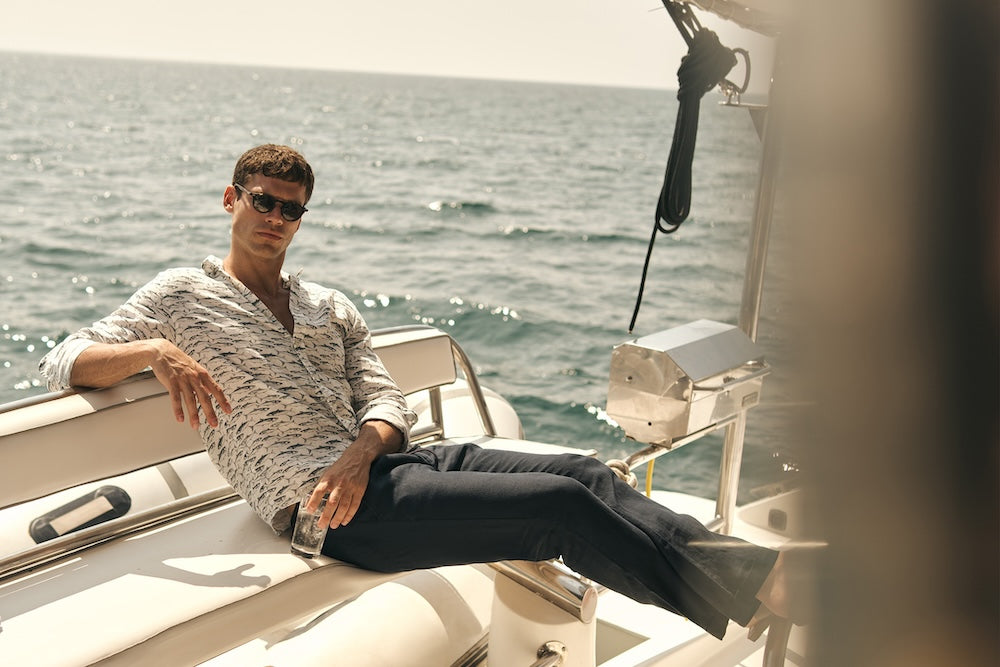 Man sitting on a boat with ocean in the background.