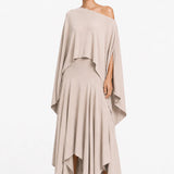 Woman wearing a beige one-shoulder blouse and layered skirt on a white background.