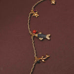 Necklace with fish and turtle charms on a brown background