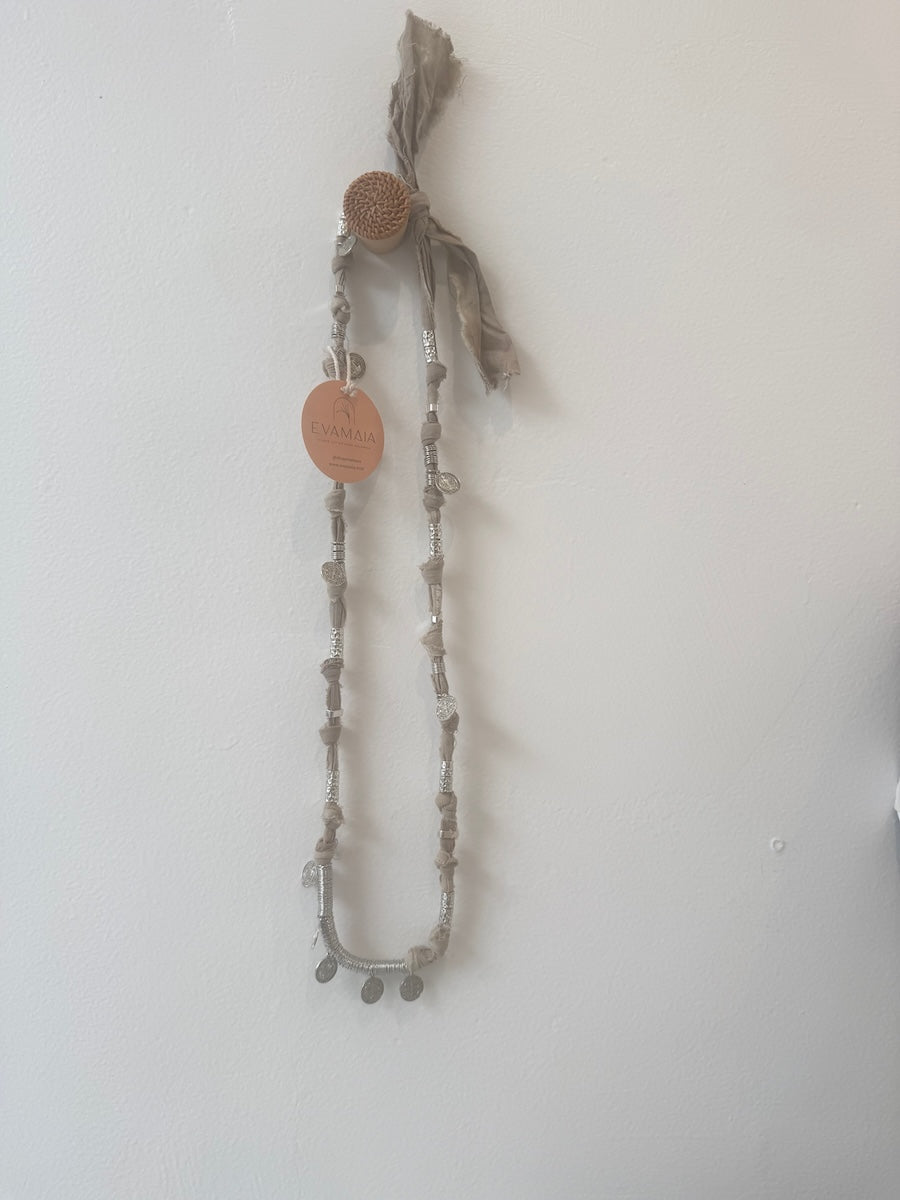 Necklace with circular pendants on a plain background
