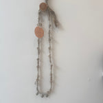 Necklace with circular pendants on a plain background